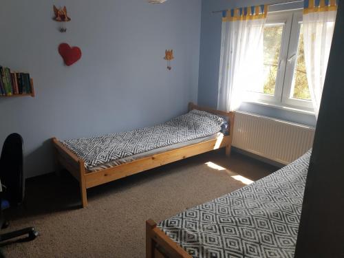 una camera da letto con due letti e una finestra di Apartament Pod Sosnami 1 Noclegi OTW Borówno Wlk Skarszewy a Skarszewy