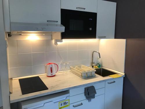 a small kitchen with a sink and a microwave at Roland apartment WestND in Budapest