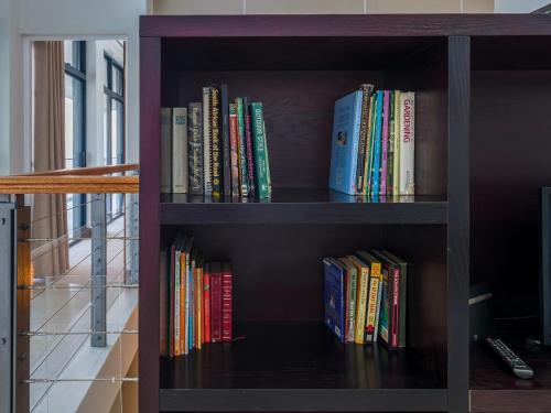 a book shelf with many books on it at Anchor's Haven Hersham in Groot Brak Rivier