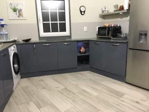 een keuken met blauwe kasten en een magnetron bij Quinta Vale de Luz in Silves