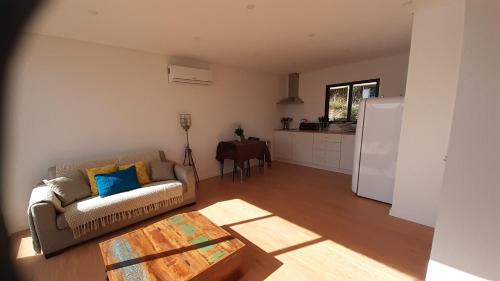 a living room with a couch and a kitchen at Bungalow da Bela Vista, Ribas, Celorico de Basto in Celorico de Basto