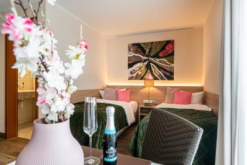 a hotel room with two beds and a table with flowers at Princess No3 Self Check-In Plochingen bei Stuttgart in Plochingen
