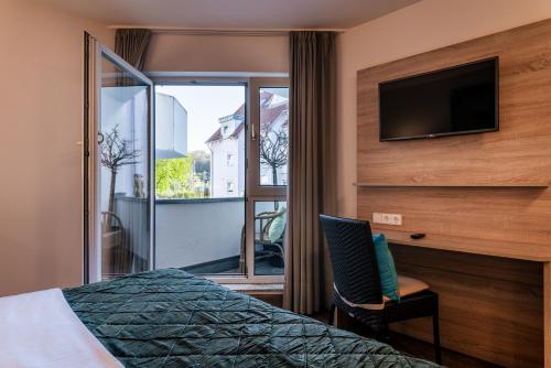 a bedroom with a bed and a tv and a window at Princess No3 Self Check-In Plochingen bei Stuttgart in Plochingen