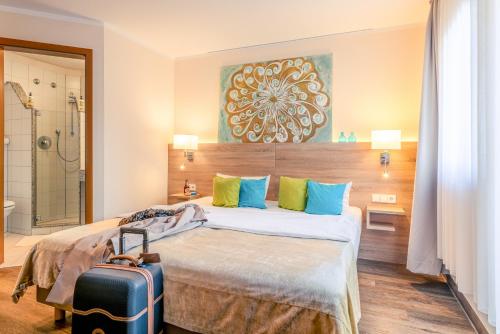a hotel room with a bed and a suitcase at Princess No3 Self Check-In Plochingen bei Stuttgart in Plochingen