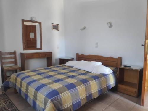 1 dormitorio con cama, mesa y espejo en Catherine Portaria Guest House, en Portaria