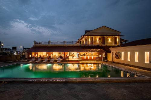 a swimming pool in front of a building at night at Manigram Bishram Batika Pvt Ltd in Bhairahawa