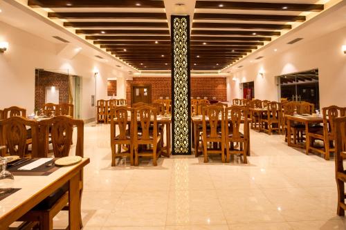 a dining room with wooden tables and chairs at Manigram Bishram Batika Pvt Ltd in Bhairahawa
