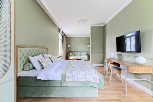a bedroom with a bed and a desk and a television at Nowy Gurewicz in Otwock