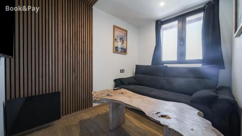 Una sala de estar con un sofá y una mesa de madera. en Chez Rémy, en Les Angles