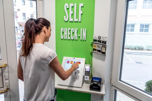 a woman is using a self check in machine in a store at Princess No3 Self Check-In Plochingen bei Stuttgart in Plochingen
