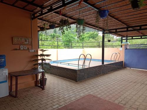 uma grande piscina num quarto com uma mesa em BIOVILLAS em Yelagiri