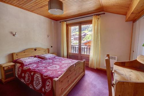 une chambre avec un lit et une grande fenêtre dans l'établissement GRAND APPARTEMENT - PROCHE DES REMONTEE MECANIQUES - MORZINE - 10 personnes - OUTO, à Morzine