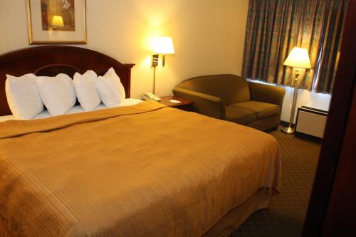 a hotel room with a bed and a chair at Quality Inn Shenandoah Valley in New Market
