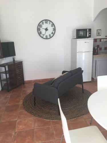 un salon avec un canapé et une horloge au mur dans l'établissement Gîte 2 pièces au calme, aux Arcs-sur-Argens