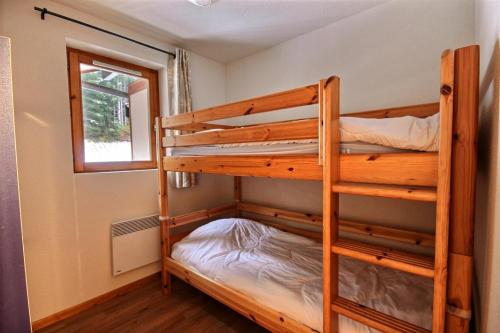 two bunk beds in a small room with a window at APPARTEMENT SPACIEUX AVEC BALCON - SAINT JEAN D AULPS STATION - 8 Personnes - OURSON 57-58 in Saint-Jean-dʼAulps