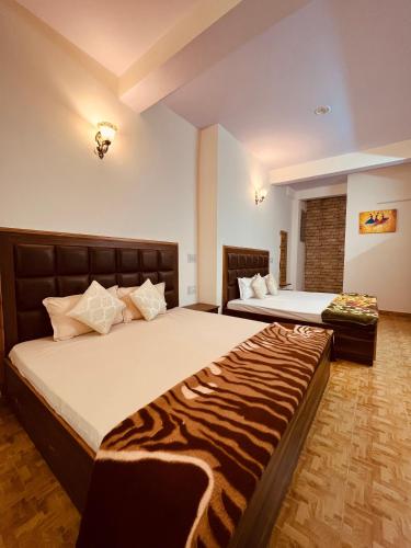 two beds in a room with a zebra blanket at Residence Inn Homestay in Shimla