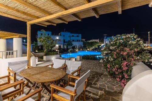 a patio with a table and chairs and a pool at Naxian Queen Luxury Villas & Suites in Agia Anna Naxos