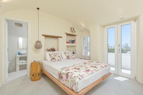 a white bedroom with a large bed and a window at Naxian Queen Luxury Villas & Suites in Agia Anna Naxos