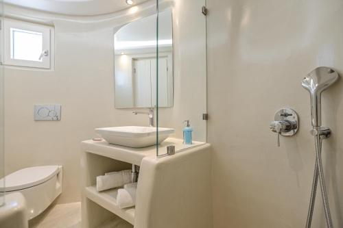 a white bathroom with a sink and a shower at Naxian Queen Luxury Villas & Suites in Agia Anna Naxos