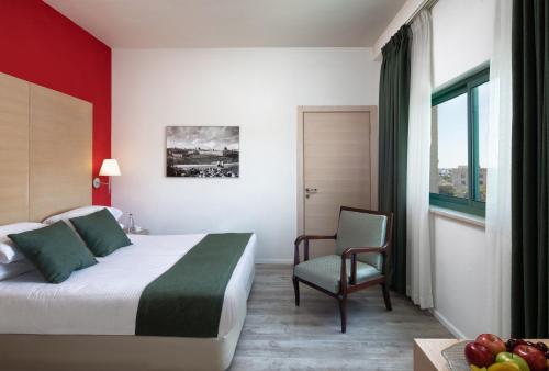Pokój hotelowy z łóżkiem i krzesłem w obiekcie Legacy Hotel w Jerozolimie
