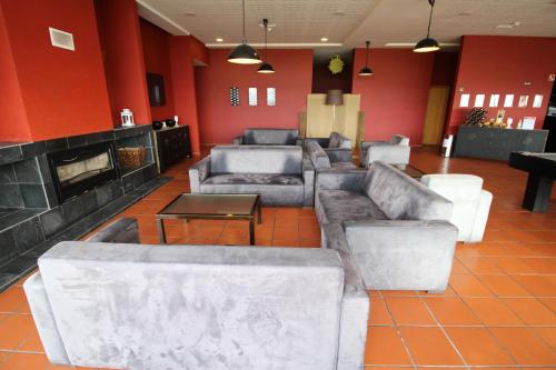 a living room with couches and a fireplace at Hotel Da Montanha in Pedrógão Pequeno