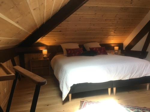 a bedroom with a white bed in a attic at Maison d'hôtes La Bageatière - Lac d'Aiguebelette in Lepin-le-Lac