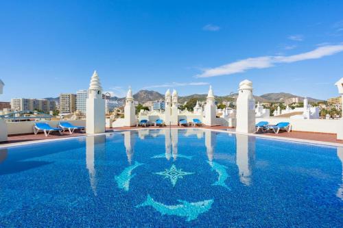 una piscina de agua azul en un complejo en Benalmadena Costa Sol Holiday Rentals, en Benalmádena