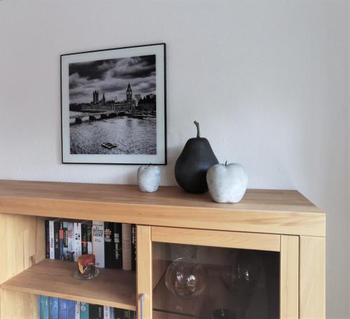 a book shelf with a picture on the wall at Ferienwohnung Falkenhof in Lindlar