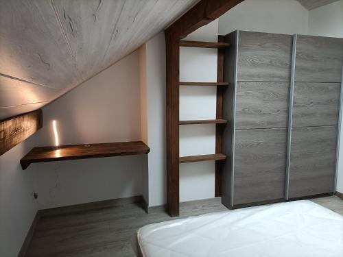 a bedroom with a bed and a book shelf at La clé du Champ in Le Clerjus