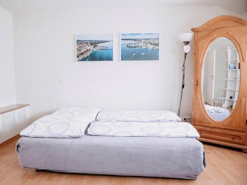 Bett in einem Zimmer mit zwei Bildern an der Wand in der Unterkunft Ferienwohnung Auszeit am See in Moos
