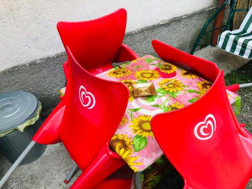 un tavolo e due sedie rosse con un tavolo di Casa di Aristide a Erba