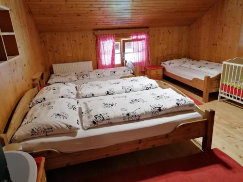 a room with three beds in a wooden cabin at Hausbergerhof Gästehaus Ainberger in Brixlegg
