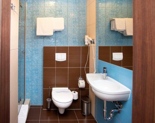 a bathroom with a toilet and a sink at Hotel Styl 70 in Pszczyna