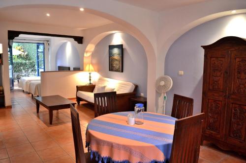 una habitación de hotel con una mesa y un dormitorio en Posada del Cafeto en Xalapa