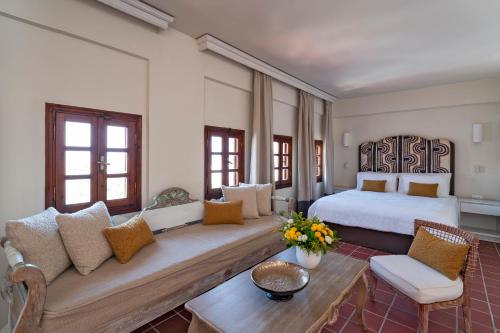 a hotel room with a bed and a couch at Maris Lindos Suites & Apartments in Lindos