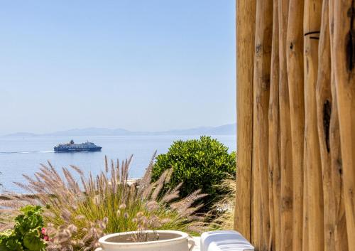 un crucero en el agua con una valla de madera en Big Blue Suites & Apartments en Kionia