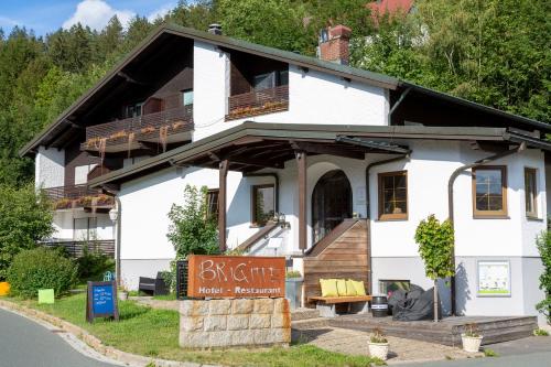a white house with a sign in front of it at Hotel Restaurant Brigitte in Warmensteinach