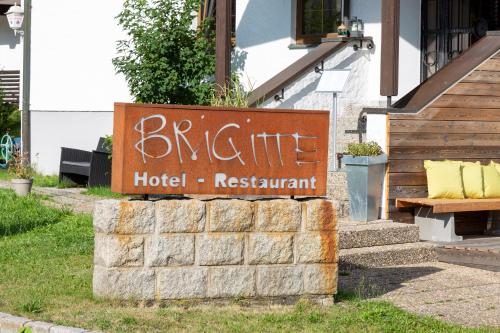 a sign for a hotel in front of a building at Hotel Restaurant Brigitte in Warmensteinach