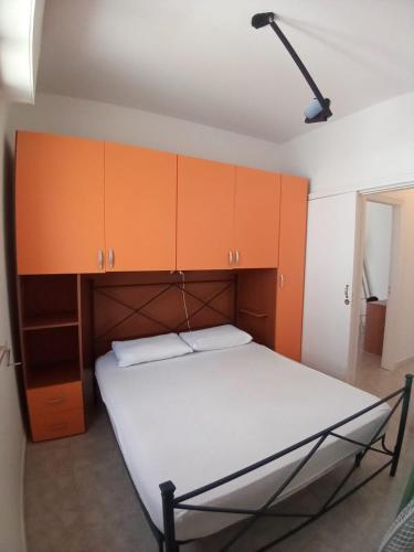リド・マリーニにあるCasa Lido Mariniのオレンジ色のキャビネットが備わるドミトリールームのベッド1台分です。