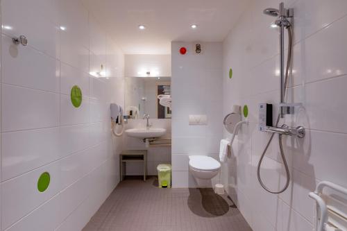 a bathroom with a shower and a toilet and a sink at Kyriad Lyon Est - Saint Bonnet De Mure in Saint-Bonnet-de-Mure