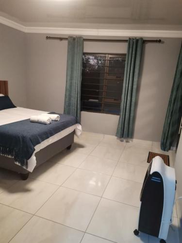 a bedroom with a bed and a window at Unogwaja Rest in Marloth Park