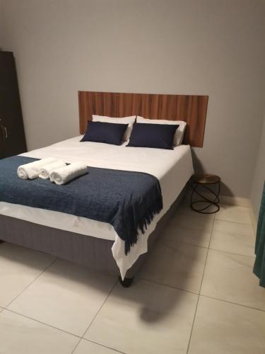 a bedroom with a large bed with blue pillows at Unogwaja Rest in Marloth Park