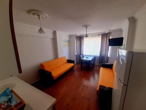 a living room with an orange couch and a table at Zeytindali Apart Hotel in Didim