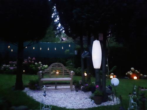 a bench in a garden at night with lights at RELAXX Home in Woryty