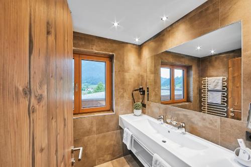 a bathroom with a sink and a mirror at Aparthotel Bergland in Söll