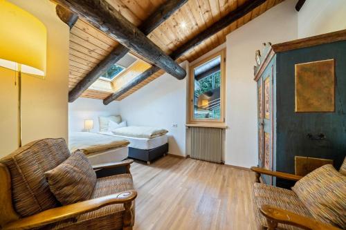 een kamer met een bed, 2 stoelen en een raam bij Chalet Marianna in Meltina