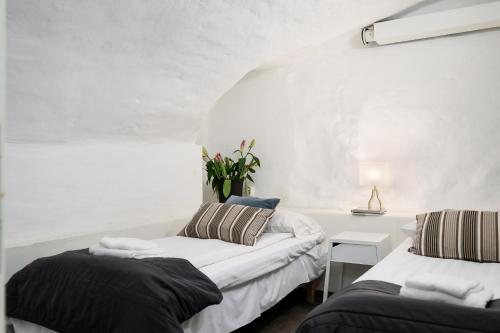 a room with two beds and a table with a lamp at Hotell Skeppsbron in Stockholm