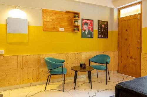 a room with two chairs and a table at Whoopers Hostel Manali in Manāli