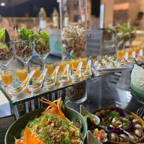 a buffet with plates of food and glasses of wine at Grand Sylhet Hotel & Resort in Sylhet
