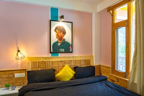 a bedroom with a bed and a painting on the wall at Whoopers Hostel Manali in Manāli